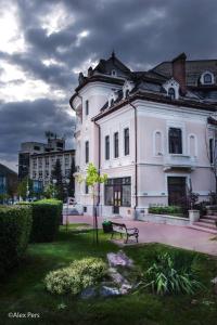 a large white building with a bench in front of it at KM 0 Residence in Piatra Neamţ