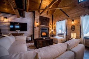 a living room with a couch and a fireplace at Les 3 Cavaliers - Les Chalets Spa Canada in La Malbaie
