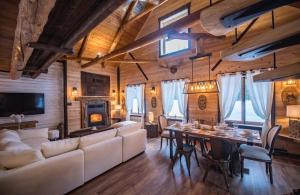 a living room with a white couch and a table at Les 3 Cavaliers - Les Chalets Spa Canada in La Malbaie