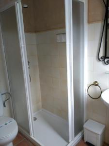 een badkamer met een douche, een toilet en een wastafel bij Apartamentos Valle del Guadalquivir in Arroyo Frio