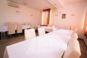 a dining room with white tables and chairs at Bed and Breakfast Helena in Kaštela