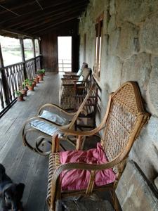 une rangée de chaises assises sur une terrasse couverte dans l'établissement Reitoral de Chandrexa, à Parada del Sil