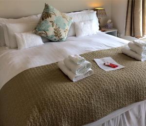 a bedroom with a bed with towels on it at Meadow Lodge in Tideswell +16 photos