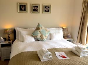 a bedroom with a white bed with towels on it at Meadow Lodge in Tideswell