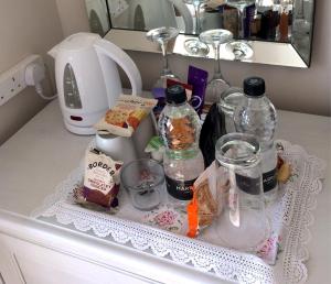 a kitchen counter with bottles and other items on a table at Meadow Lodge in Tideswell