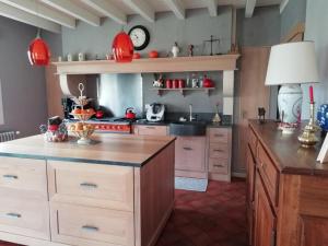 a kitchen with red lamps and a counter top at Chambres d'Hôtes Mado et Lulu in Collonges-au-Mont-dʼOr