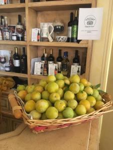 a basket of green apples and bottles of wine at Hotel Monreale in Sardara