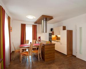 a kitchen and dining room with a table and chairs at Parkvilla Appartements in Bad Hofgastein