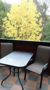 Una mesa y dos sillas frente a una ventana. en Apartament Parkowa Polana, en Polanica-Zdrój