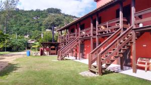 a red building with stairs on the side of it at Condominio Sargento Laranja in Garopaba
