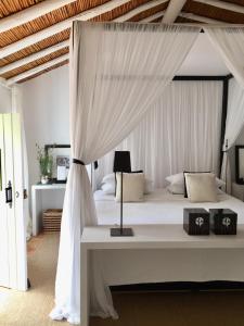 a bedroom with a white bed with a canopy at Quinta da Lua in Tavira