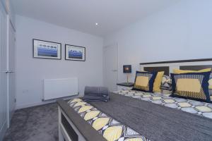 ein Schlafzimmer mit einem großen Bett mit gelben und blauen Kissen in der Unterkunft Sandbanks Road in Poole