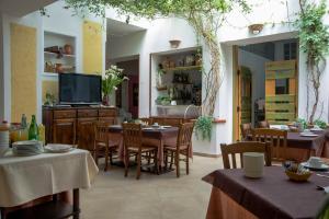 a restaurant with tables and chairs and a flat screen tv at Hotel Silvestrino in Stintino