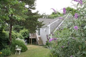 a backyard with a house and a deck with purple flowers at Lavender Bay in Barnstable