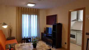 Una televisión o centro de entretenimiento en Apartamentos Puerta Muralla