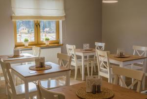 uma sala de jantar com mesas e cadeiras e uma janela em Willa Malinka Wisła em Wisła