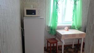 ウシンスクにあるАпартаменты на Возейской, 3 (7эт)の電子レンジ、冷蔵庫、テーブルの横