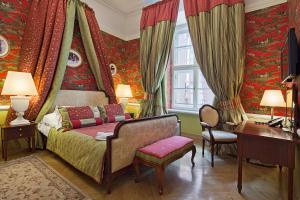 sypialnia z łóżkiem, biurkiem i zasłonami w obiekcie The Bonerowski Palace Boutique Hotel w Krakowie