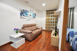 uma sala de estar com um sofá e uma cama em Apartamentos Hemar Granada em Granada