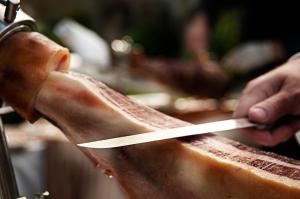 a person cutting a piece of meat with a knife at Hotel Pazo Los Escudos Spa & Beach in Vigo