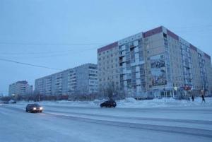 ウシンスクにあるApartment on Neftyanikov 48の建物前の道を二台走行