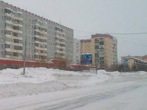 ウシンスクにあるApartment on Neftyanikov 48の背景の高い建物が並ぶ雪道