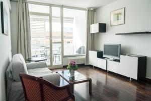 salon z kanapą i telewizorem w obiekcie Darsena Apartment w Genui