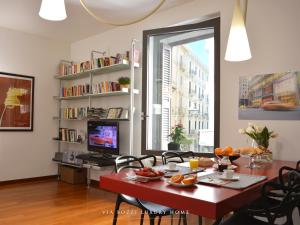 salon z czerwonym stołem i telewizorem w obiekcie Via Bozzi Luxury Home w mieście Bari