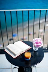 - une table avec un livre ouvert, une bougie et des fleurs dans l'établissement Hotel Villa Iulia, à Ventotene