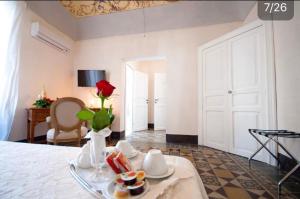 a hotel room with a tray of food on a bed at Sveva rooms in Noto