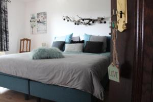 Un dormitorio con una cama azul con almohadas. en (La parenthese) en Hombourg