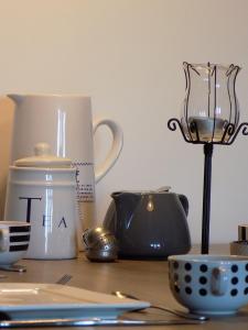 a table with utensils and a tea pot and a cup at (La parenthese) in Hombourg