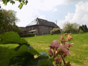 una casa vieja en un campo con una flor delante en (La parenthese) en Hombourg