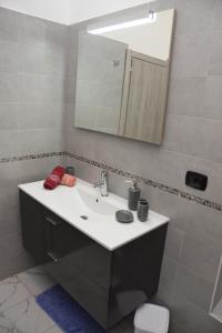 a bathroom with a sink and a mirror and a toilet at Casa di Bacco in Vetralla