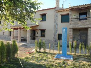 un edificio con una escultura azul delante de él en Casa la Peña, en Alpera