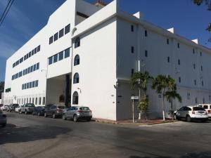 biały budynek z samochodami zaparkowanymi na parkingu w obiekcie Eurohotel w mieście Ciudad del Carmen