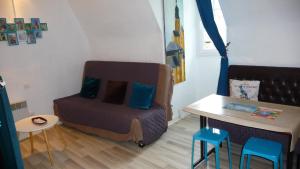 サルラ・ラ・カネダにあるLes Toits de Sarlatのベッドとテーブルと椅子のある小さな部屋