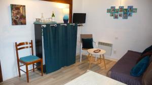 サルラ・ラ・カネダにあるLes Toits de Sarlatのリビングルーム(緑のカーテン付)