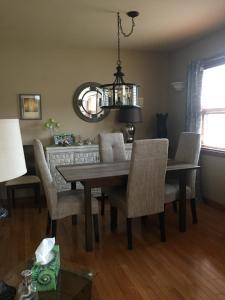 een eetkamer met een tafel en stoelen en een spiegel bij Money Pennies Bed and Breakfast in Campbell River