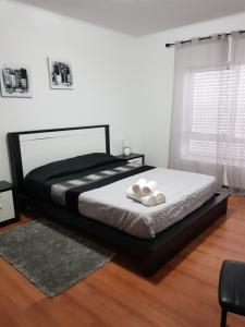 um quarto com uma cama com lençóis brancos e uma janela em Apartamento Moderno e Elegante em Ponta Delgada
