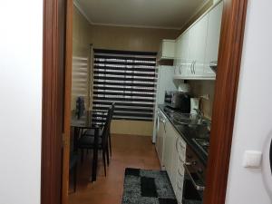 a small kitchen with a table and a dining room at Apartamento Moderno e Elegante in Ponta Delgada
