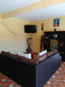 un sofá grande en una sala de estar con TV en El Sueño de Quetzalcoatl, en San Juan Teotihuacán