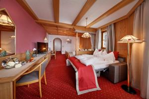 ein Hotelzimmer mit einem Bett und einem Esszimmer in der Unterkunft Panorama Vital Hotel Rimmele in Dorf Tirol