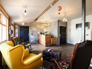 a living room with yellow chairs and a counter at The Garage in Varmahlíð