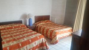 une chambre avec deux lits dans une pièce dans l'établissement Paseo Vallarta, à Bucerías