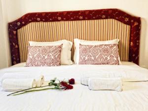 Una cama blanca con toallas y flores. en Vila Algarvia Boutique & Suites, en Albufeira