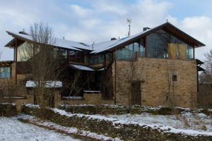 a large brick house with glass windows in the snow at Alojamiento Luz de Hadas in Sampil