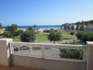a balcony with a view of a park and the ocean at Cala Azul 304-306 Tamarit in Tamarit