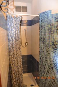 a bathroom with a shower with a shower curtain at Appartamenti Belvedere in SantʼAntìoco