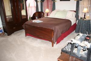 um quarto com uma cama grande e uma cadeira em Woodrow House Bed & Breakfast em Lubbock